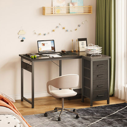 Black 100cm x 70cm L-shaped desk with 4 fabric drawers in a bedroom home office scene, with right-side fabric drawer storage, side hanging pocket, and space-saving corner layout.