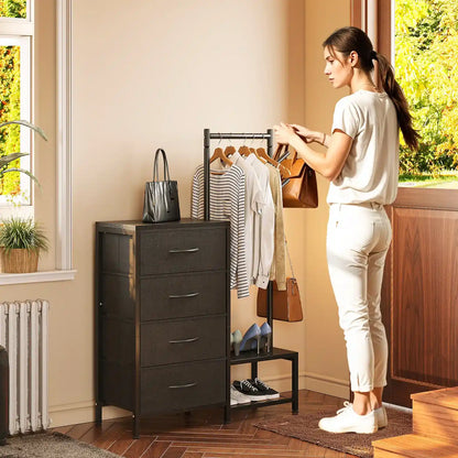 A woman stands beside a dark gray 4-drawer storage cabinet in a bright room, with a clothing rack, bags, and shoes nearby.